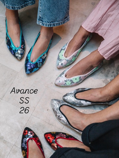 A top-down view showing four pairs of colorful, sequin-covered flat shoes worn by models to showcase the brand's new collection variety.