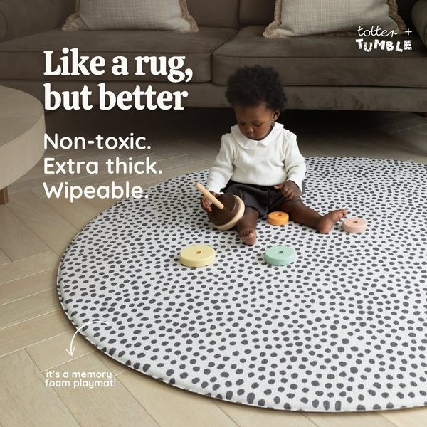 A high-contrast, clean lifestyle shot of a toddler playing on a patterned round memory foam mat, highlighting core material benefits.
