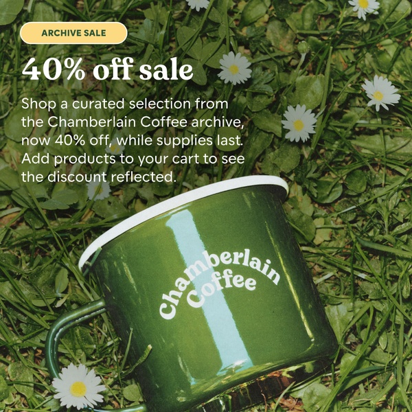 A square-formatted sale creative featuring an enamel coffee mug nestled in grass with scattered white flowers.