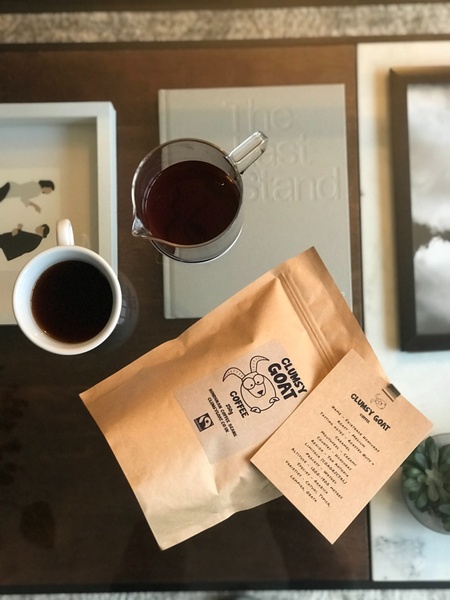 An overhead flat-lay shot of artisanal coffee beans, a brewed cup, and a French press on a wooden surface, emphasizing a premium lifestyle aesthetic.