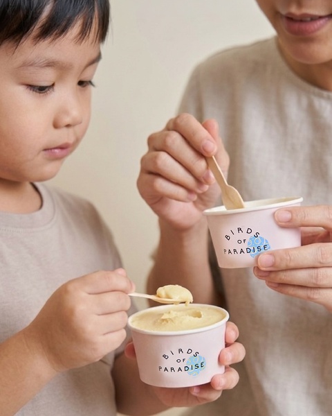 A close-up shot showing an adult and a child sharing ice cream in branded cups, emphasizing a personal and approachable brand connection.