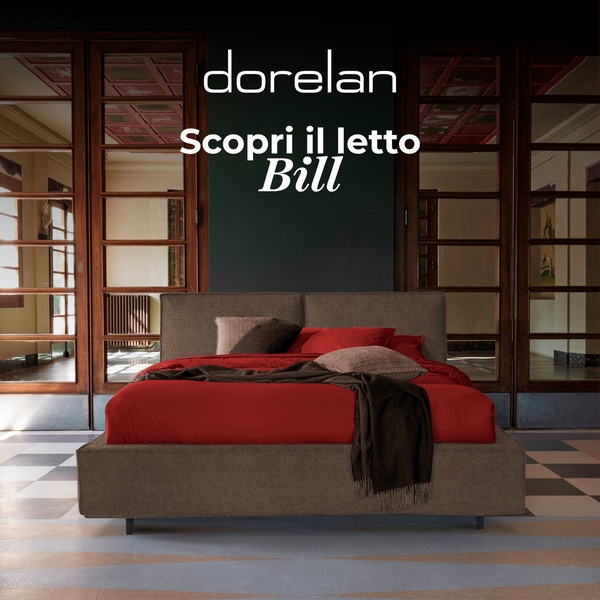 A high-end studio shot of a brown upholstered bed with deep red bedding, set against a dark, moody, and architectural background.