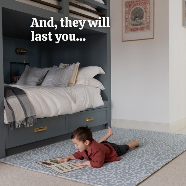 This 1:1 ad creative features a young child playing on a stylish blue patterned area rug, emphasizing durability through a bold text overlay.
