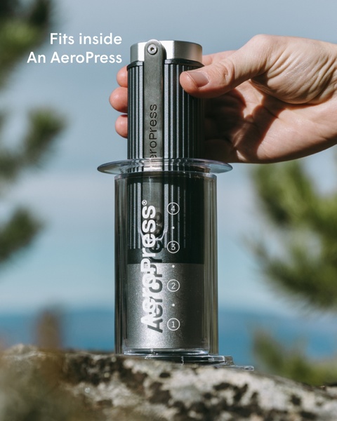 This ad demonstrates the compact design of an AeroPress by showing it fitting perfectly inside its own carrying component, highlighting convenience through visual proof.