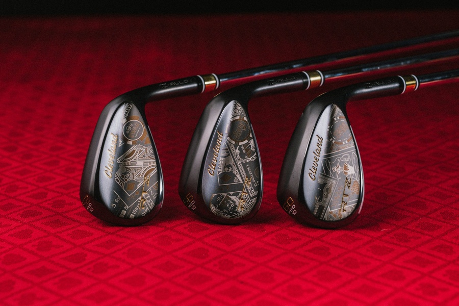 A high-end, detailed close-up of custom golf wedges featuring intricate, casino-themed laser engravings on a red felt background.