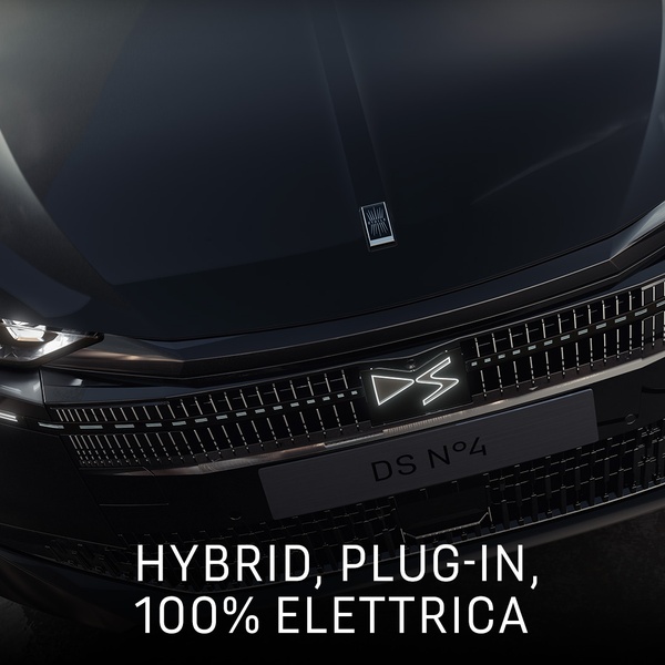 A high-end, close-up shot focusing on the vehicle's front grille, logo, and electrified powertrain options. The aesthetic is dark, moody, and premium.