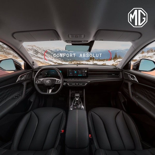 A high-fidelity POV shot from the driver's seat looking out at a mountain range, emphasizing the premium dashboard and cabin comfort of the vehicle.