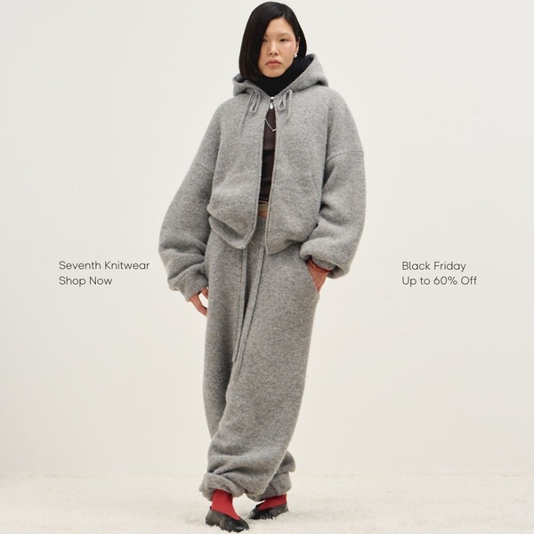 A high-quality, full-body portrait showcasing a matching grey wool tracksuit against a clean, neutral studio backdrop.