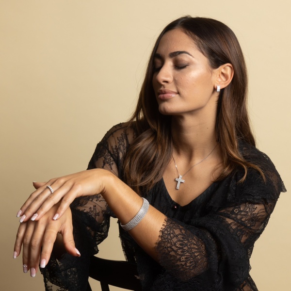 A high-end portrait featuring a woman wearing a diamond bracelet, necklace, and ring, captured against a clean neutral background to emphasize product quality.