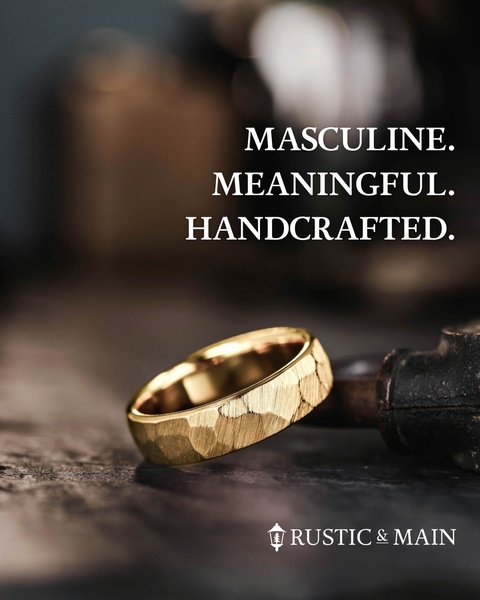 A high-end, close-up shot of a textured gold band resting on a dark, rustic surface, emphasizing craftsmanship and masculine elegance.