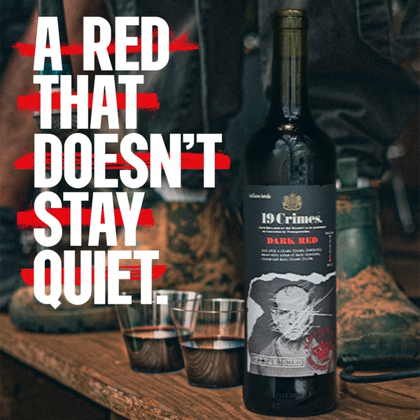 A high-contrast, moody lifestyle shot featuring a bottle of dark red wine, blurred out textures, and bold text overlays.