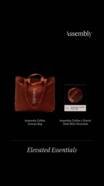 A minimalist lifestyle advertisement showcasing a canvas tote bag and dark milk chocolate set against a stark black background.