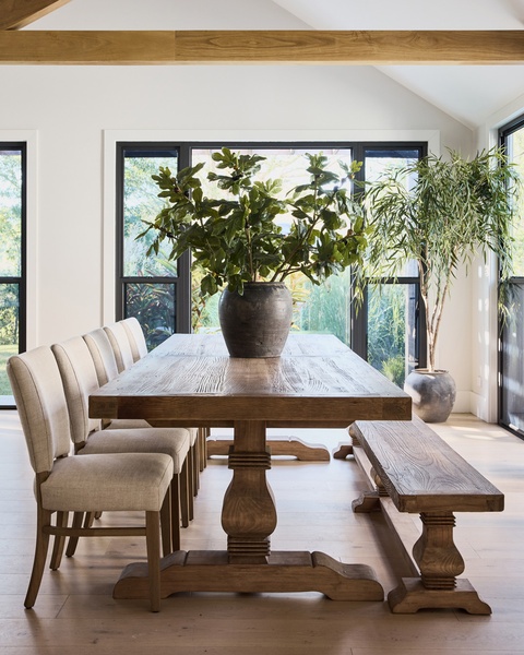 A high-end dining table set in a bright, airy room with natural wood textures, focusing on interior design aesthetic.