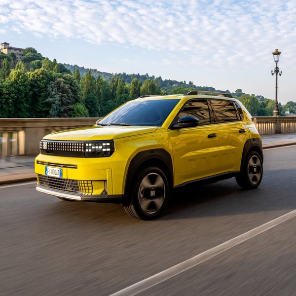 A high-visibility yellow SUV driving on an urban bridge during golden hour, emphasizing movement and premium design.