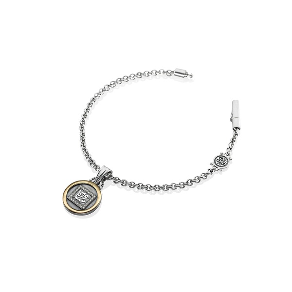 A high-end, clean studio shot of a silver charm bracelet featuring a detailed medallion pendant against a stark white background.