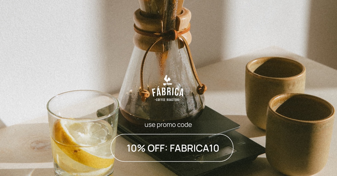 A high-quality, lifestyle-focused coffee maker ad featuring a glass brewer, citrus, and a clear promotional offer code.