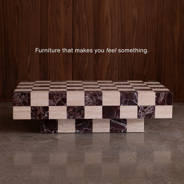 A high-end 1:1 square ad creative highlighting a checkered marble coffee table against a dark wood background.