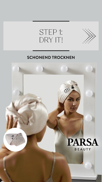A clean, instructional creative showing a woman using a specialized hair drying towel in front of a mirror to demonstrate a clear beauty routine step.