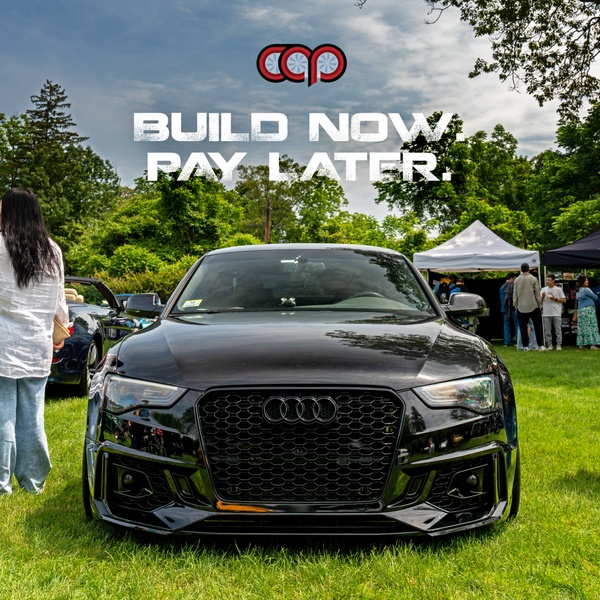 An outdoor, daytime shot of a modified black sports car parked on a lawn, featuring bold text overlaying the image to advertise a financing incentive.