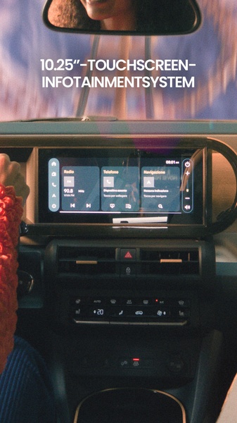A close-up POV shot from the driver's perspective showcasing a sleek 10.25-inch touchscreen infotainment display inside a modern vehicle.