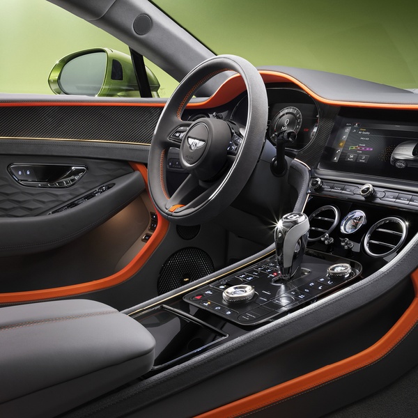 A close-up, high-definition view of a high-end car interior, emphasizing premium materials, bold color contrast, and an immersive, driver-centric cockpit.