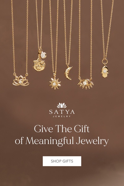 A high-end, minimalist aesthetic showcases multiple gold pendants against a warm, neutral background to emphasize meaningful gifting.