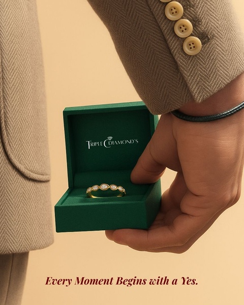 A high-end, close-up shot of an engagement ring inside a branded green box, held by a person in a sophisticated beige suit.