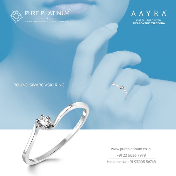 A close-up, high-contrast hero shot of a delicate Swarovski zirconia ring against a clean, soft-blue background with subtle branding.