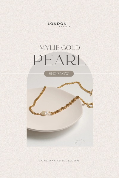 A refined product hero shot featuring a gold pearl necklace displayed on a ceramic dish against a neutral, textured background.
