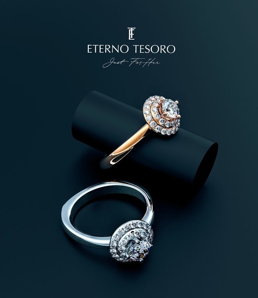 A high-end, clean product shot featuring two diamond rings resting on a dark cylindrical base, emphasizing luxury and precision.