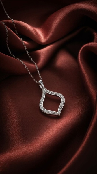 A high-end, close-up shot of a delicate diamond pendant necklace draped over deep red, luxurious silk fabric.