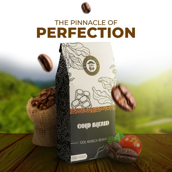 A high-quality product shot featuring a bag of Gold Blend coffee beans, surrounded by floating beans and natural, mountainous background elements.