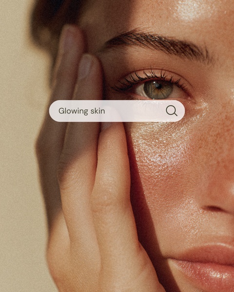 A close-up aesthetic shot of a model's face overlaid with a digital search bar labeled 'Glowing skin' to emphasize product benefit.