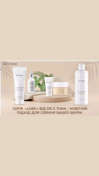 A minimalist, studio-style product arrangement of a brightening skincare range displayed on a pedestal against a soft neutral background.