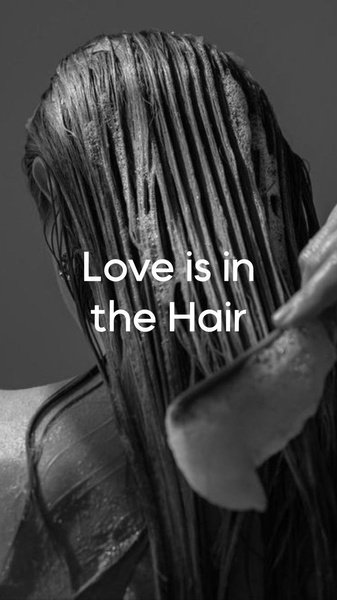A close-up, monochromatic shot of a person conditioning their hair, featuring simple, bold text centered on the screen.