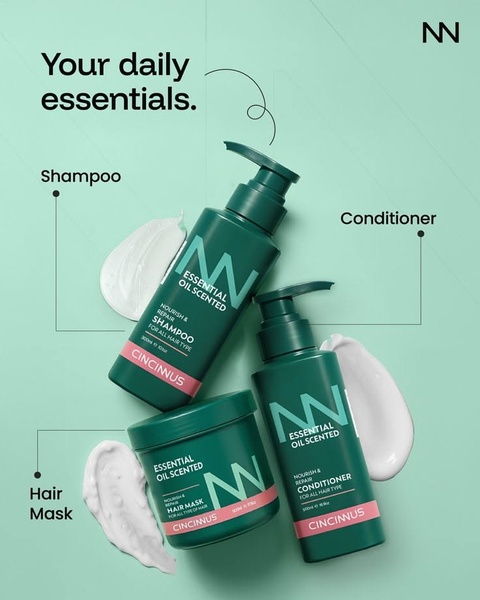 A clean, studio-lit composition of three hair care products arranged with corresponding cream swirls on a soft mint background.