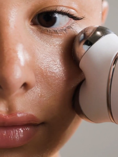 A high-definition, tight-crop shot showing a facial massager gliding over skin, emphasizing the product's interaction with the user's complexion.