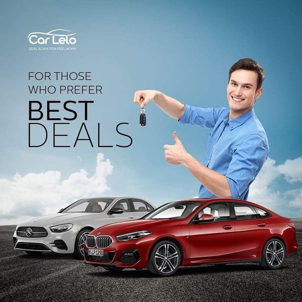 A high-contrast ad featuring a cheerful man holding car keys next to two luxury vehicles against a clear sky, communicating an exclusive deal.