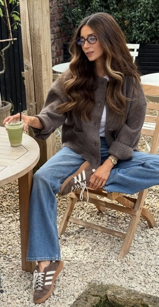 A high-quality lifestyle shot featuring a model in a casual cafe setting, showcasing the suede sneakers as part of a relaxed, everyday outfit.