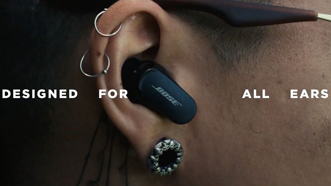 A close-up, high-definition shot of an earbud worn by a user, focusing on clean design and an inclusive, universal messaging approach.