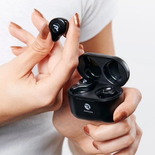 A close-up, high-quality product photo featuring a pair of black wireless earbuds and their charging case held in a person's hands.