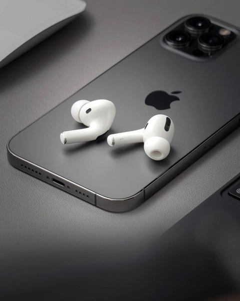 A clean, studio-lit close-up shot of white wireless earbuds resting on a matte dark gray smartphone, emphasizing a sleek and modern aesthetic.