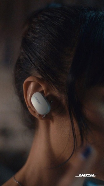 A close-up, high-fidelity hero shot of a person wearing a single wireless earbud, emphasizing the sleek design and fit.