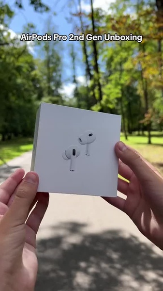 A high-quality 9:16 vertical video frame featuring a clean, outdoor, hands-on unboxing of electronic earbuds.