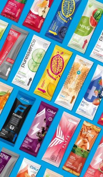 A high-angle flat-lay photograph showcasing a diverse collection of flavor cartridges in a structured diagonal grid pattern on a bright blue background.