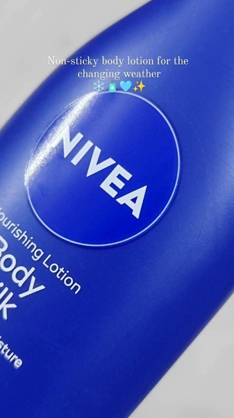 A close-up product shot of Nivea body lotion featuring a text overlay that addresses seasonal skincare needs with a clean, minimalist aesthetic.