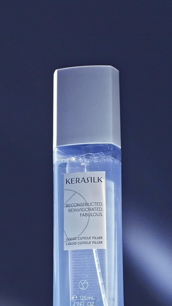 A close-up, high-contrast shot of a Kerasilk liquid cuticle filler bottle against a dark, moody background.