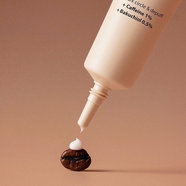 This creative showcases an eye cream being dispensed directly onto a single coffee bean, visually emphasizing the caffeine ingredient.
