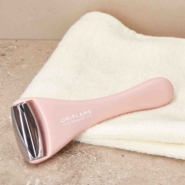 A high-quality studio shot of a light pink facial roller resting on a clean, textured white towel to emphasize product aesthetics.