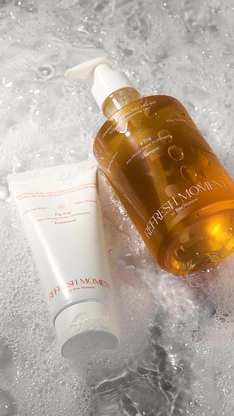 This creative showcases the brand's shampoo and treatment bottles submerged in rich cleansing foam, emphasizing a sensory and refreshing product experience.